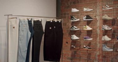 Bir moda giyim mağazasında çeşitli kot pantolonlar ve spor ayakkabıları sergileniyor. Bu mağaza geniş bir sokak giysisi yelpazesi sunuyor. Moda, perakende, Chisinau, Moldova - 18 Ocak 2025