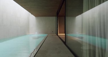 Zarif, modern bir kapalı havuzda yüzen iki kişi. Mimari tasarım temiz çizgiler ve doğal ışık içerir. Rahatlama ve rahatlama temaları için ideal. Modern Kapalı Yüzme Havuzu