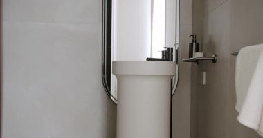 Pürüzsüz ve modern minimalist banyo iç mimarisi içinde şık bir lavabo, ayna, zarif eşyalar ve havlu tutacağı var. Çağdaş ev dekorasyonu için ideal. Banyo Minimalist Tasarımı