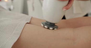 Güzellik tedavi yenileme prosedürü. Masör kozmetoloji kliniğinde selülit önleyici masaj yapıyor. Güzel bir kadın güzellik salonunda selülit ve yağ önleyici terapi görüyor..