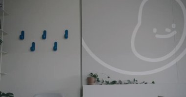 Zarif renkler ve parlak dekorasyonlarla minimalist iç tasarımı olan çağdaş bir ofis alanı. Basitlik ve modern estetiğe odaklanın, sakin ve profesyonel ortamları aktarın.