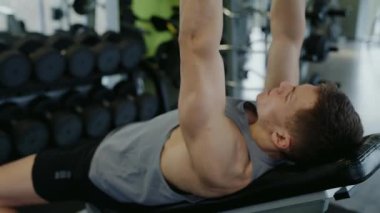 İyi donanımlı bir spor salonunda ağırlık kaldırma egzersiziyle mücadele eden, kendini işine adamış ve güçlü bir genç. Modern Spor Salonu 'nda Bench Press Egzersizi Yapan Genç Adam