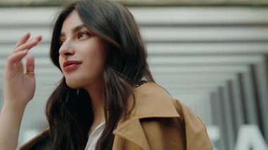 Kendine güveni ve sakinliğini ifade eden şık kıyafetler ve doğal ışıkla dolu şehir ortamında kendine güvenen bir kadının portresi. Kentin sokaklarında yürüyen kendinden emin genç bir kadın.