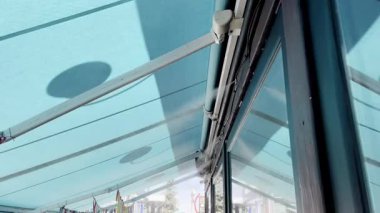 Sıcak bir yaz gününde açık mavi bir tentede serinletici bir sis püskürtür. Sis havayı serinletir ve sıcaktan korur. Tentenin altında oturan insanlar serin sislerin tadını çıkarırlar..