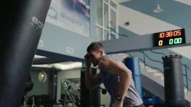 Niagara Spor Salonu 'nda kum torbasıyla boks yapmaya odaklanmış, iyi donanımlı bir spor salonunda çalışıyor. Modern Spor Salonunda Genç Adam Kum Torbasıyla Sıkı Çalışıyor