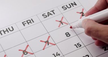 Kırmızı kalemle takvimdeki günlerin üstünü çizen bir kişinin yakın plan resmi, zamanın akışını ya da bir olaya geri sayımı gösterir. Takvimdeki Günleri Kırmızı İşaretli Kalemle Silen Kişi