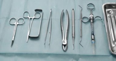 Sağlık hizmeti konsepti. Diş hekimlerinin masasındaki dişleri incelemek için gerekli aletler. Diş çekmek için modern bir diş kliniğinde steril aletler.