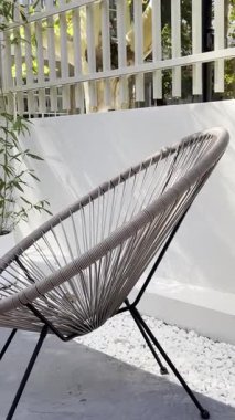 Rahatlatıcı bir açık alan şık bir Acapulco sandalyeye sahiptir, gevşemek için mükemmeldir. Beyaz çakıl taşları ve yemyeşil bambu temiz beyaz bir duvar ve çite karşı sakin bir ortam yaratır. Yaşam tarzı, tasarım