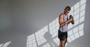 Atletik adam yoğun bir şekilde stüdyoda antrenman yapıyor, kas yapısını ve dikkatini gösteriyor. Atletik Genç Adam Stüdyoda Yoğun Çalışmalara Başladı