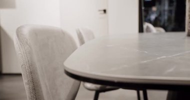 Modern gray and white kitchen furniture with marble table. Elegance and Comfortable Home, Warm cozy. Leather modern gray chair in living room with kitchen and dining table. Modern Minimalist Home.