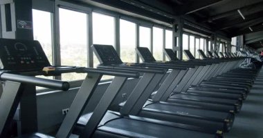 Modern bir spor salonunda panoramik pencereleri manzaralı koşu bantları. Spor ve sağlık konuları için ideal. Koşu bantlı Modern Spor Salonu Şehir Görüş Alanında