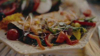 Taze sebzelerin sunulduğu lezzetli bir vejetaryen yemeğinin yakın çekimi çok güzel bir tabakta servis ediliyor. Sağlıklı gıda, vejetaryen ve organik gıda temaları için ideal.