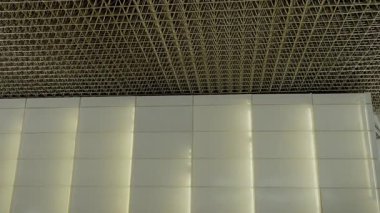 Tavan deseni, yansımalar ve hafif ışıklandırma efektleri de dahil olmak üzere düz duvar panelleriyle yan yana. Geniş Tavan ve Duvarın Modern Mimari Detayları