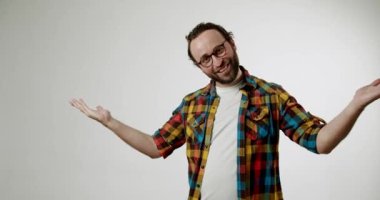 Gözlük takan neşeli bir adam ve renkli ekose gömlekli bir adam elleriyle hareket ediyor ve beyaz bir arka planda iki başparmak işareti yapıyor. Arkadaş canlısı ve misafirperver görünüyor. Olumlu ve mutabık olduğunu söylüyor..