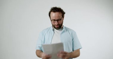 Açık mavi gömlekli ve gözlüklü bir adam kâğıt üzerinde aldığı olumlu habere sevinçle tepki verir. Bu bilgi onu çok heyecanlandırdı ve memnun etti. İş, finans ve iyi haber kavramları için mükemmel..