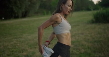 Genç atletik kadın antrenmandan önce ısınıyor. Spor anlayışı, egzersiz. Aktif koşucu, kardiyo egzersizinden önce denge çalışıyor. Olgun Kafkas Sporcusu Koşmadan Önce Esneme.