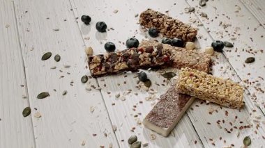 Kırsal bir ahşap masada çeşitli fındıklı ve yabanmersinli granola barları. Sağlıklı bir aperatif ya da kahvaltı için mükemmel, doğal malzemeleri vurgulamak ve sağlıklı yemek için..