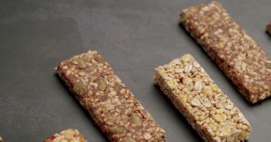 Koyu bir arka planda sergilenen çeşitli sağlıklı granola barların yakın çekimleri. Besleyici atıştırmalıklar ve organik gıda ürünleri sergilemek için mükemmel. Koyu Arkaplan Yakın Çekimde Sağlıklı Granola Çubukları