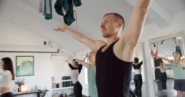 Erkekler ve kadınlar stüdyoda birlikte esniyorlar. Spor salonu, spor aktivitesi, kapalı alanda birlikte yoga dersinde sağlıklı yaşam tarzını geliştirmek ve esnetmek. Yoga Kulübü. Konsantrasyon.