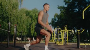 Doğayla iç içe olan bir spor salonunda spor yapan atletik bir genç. Güneşli bir günde sağlık, sağlık ve etkin yaşam tarzını yeşil bir parkta teşvik ederek spor yapma alışkanlığı..