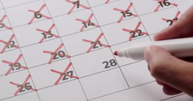 Zaman geçişini, planlamasını, izlemesini ve zaman yönetimini gösteren kırmızı işaretli bir takvimin yakın plan görüntüsü.