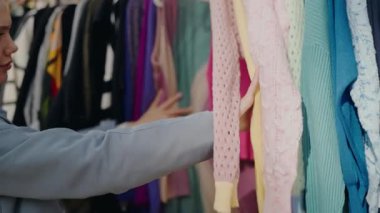 Dolu bir gardıropta çeşitli renkli giysileri karıştıran, kıyafet seçen bir insanın yakın çekim görüntüsü. Dolu Dolaptan Renkli Kıyafetler Seçen Kişi