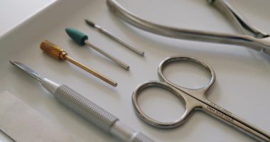 Çivi bakım aletleri. Profesyonel aletler, tırnak törpüsü, makas, meme uçları ve manikür için kuaför. Tırnak bakımı prosedürü için tepside steril aletler.