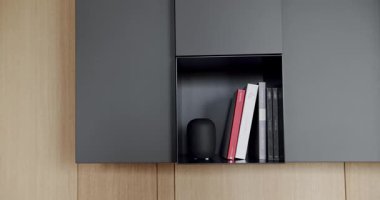 Ahşap duvarlı ve gri mobilyalı modern Minimalist oturma odası. Rafları ve kitabı olan samimi, modern mobilya tasarımı. Köşedeki kanepe ve kitaplığı olan Modern Ev İçi.