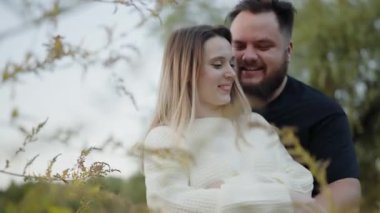 Sevgi dolu bir çift, sakin bir açık hava ortamında sevgi ve mutluluk göstererek kucaklaşır. Neşeli bir yakınlık anı yakalandı. Doğal Ortam 'da Romantik Kucaklaşma, Sevgi ve Neşeyi Paylaşan Çift