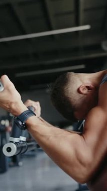 Kararlı genç bir adam spor salonunda yoğun bir idman yapıyor. Çaba ve güç gösterisi yapıyor. Spor Salonunda Dikey Egzersiz Yapan Kararlı Genç Adamla Yoğun Egzersiz