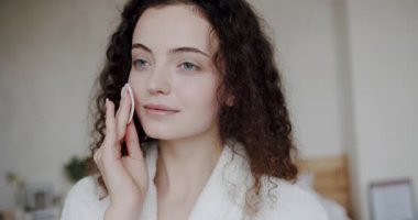 Vücut bakımı. Güzel bir kadın elinde pamuk tutarak kirliliğini temizler mükemmel cildini temizler. Sağlıklı cilt ve temizlik için makyaj malzemelerini çıkarmak için yüz yastıklı gözler kapalı ve kadın modeli.