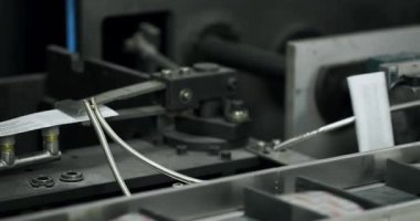 Tıp fabrikasındaki üretim hattını kapatın. Robot kol, ilaç paketini taşıma bandına koydu. Otomatik üretim hattında paketlenmiş mallar. İlaç imalatının üretim hattı.