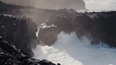 Portekiz kıyı şeridi boyunca uzanan sivri siyah volkanik kayalıklara çarpan dalgaların nefes kesici görüntüsü. Okyanustan gelen sis dramatik bir atmosfer yaratır. Güçlü Okyanus Dalgaları Çarpışıyor