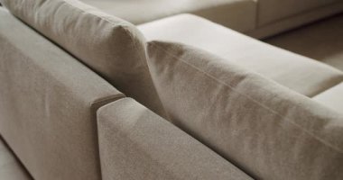 Bu resim, bej kumaş kanepenin ince dokusunu ve yumuşak rengini sergiliyor, konforu ve modern iç tasarımı vurguluyor. Bej Kumaş Koltuk Yastıkları ve Dokumasının Yakın Çekim Detayları