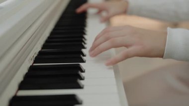 Odaklanmış genç, güzel bir kız. Elektrikli piyano çalarak eğleniyor. Müzik dersi veren genç bir müzisyen. Ev müziği stüdyosu kadını. Müzik eğitimi. Eller piyano tuşlarına basıyor..