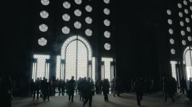 Kazablanka, Fas 'taki Hassan II Camii' nden ayrılan insanlar. Karmaşık tasarımları ve parlak ışıklarıyla büyük giriş karanlık iç mekan ile çarpıcı bir tezat yaratır..