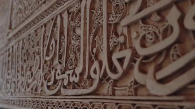 Duvara kazınmış karmaşık İslami el yazısı. Süslü tasarım, Fas mimarisinin zengin sanatsal mirasını sergiliyor. Karmaşık İslami Kaligrafi