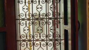 Karmaşık Fas tasarımıyla süslü metal bir kapı. Altın püskül aşağı sarkıyor ve sahneye biraz zarafet katıyor. Ilık ışık mekanı aydınlatır, sükunet ve güzellik hissi yaratır..