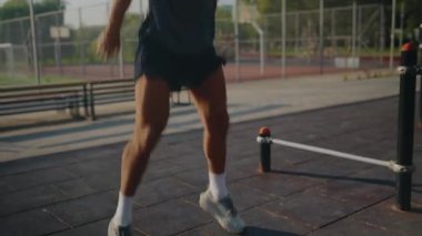 Formda bir adam açık hava parkında şınav çekerek egzersiz yapar. Forma odaklı bir ortamda güç ve kararlılık gösterir. Parlak gün açık hava aktivitelerini teşvik eder. Şınav çeken Atletik Adam