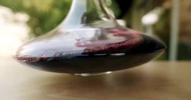 Bir şarap garsonu, kırmızı şarabı yavaş çekimde sallar. Şaraphane konsepti. Dekan ve bir kadeh kırmızı şarap. Servis edilmeden önce şarap ve kokuları temizliyorum..