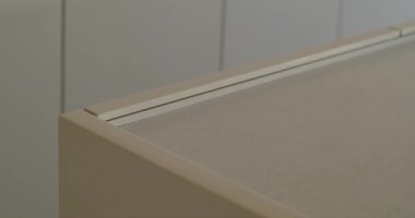 Minimalist, açık bej bir masanın köşesinde birbirine uyumlu bir duvara karşı yakın plan. Temiz çizgiler ve nötr renk bir sakinlik ve düzen hissi yaratır. ev dekorasyonu, tasarım veya yaşam tarzı içeriği.