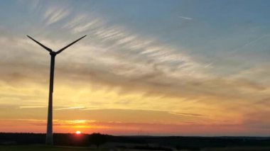 Yel değirmenlerinin siluetleri günbatımının arka planında.