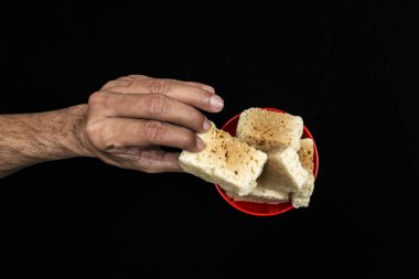 Hindistan Tatlı Hindistan Cevizi Paketi (Mysore Pak) Kırmızı Bowl 'da, Bir El Mysore Pak' ın bir parçasını aldı, Hint Mysore Pak 'ı, siyah arka planda izole edildi, Top View