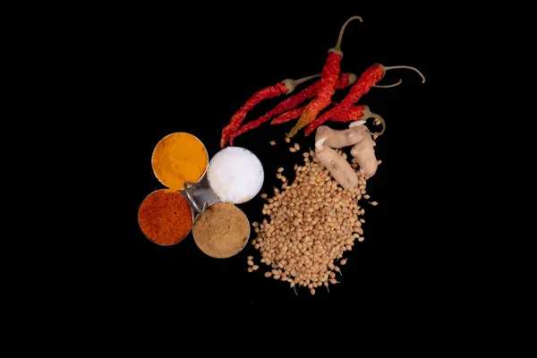 Round Bowls In Spices Like, Red Chili Powder, Turmeric Powder, Salt And Coriander Powder. Isolated On Black Background. Dried Red Chilies, Coriander Seeds And Raw Turmeric On Black Surface.