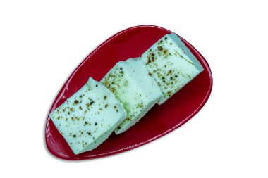 Kırmızı tabakta üç parça Kharvas, beyaz arka planda izole edilmiş tatlı bir mandıra ürünü.