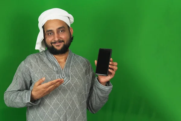 緑の画面で彼の携帯電話を示すインドの若い農家 スペースをコピー — ストック写真