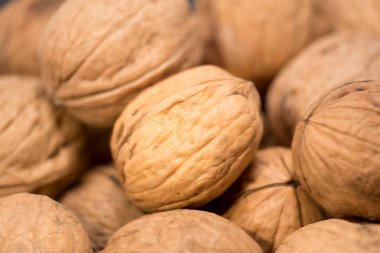 Doğal Ödül: Taze, Organik Cevizlerin Yakın Çekimi, bu resim taze, organik cevizlerin yakın çekimini içeriyor. Her ceviz, kabuğunda, sergilenen karmaşık dokular ve zengin