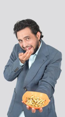 Lezzetli ve lezzetli mısır koçanı tohumu yiyen bir adamın portre görüntüsü, diğer yandan mısır koçanı tohumlarıyla dolu bir jest..