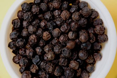 Yakın çekim ve beyaz kasedeki bir yığın karabiber..