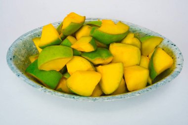Beyaz arka planda izole edilmiş bir tabakta mango dilimleri.